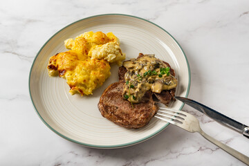 Eye fillet served with cauliflower gratin and mushroom sauce 