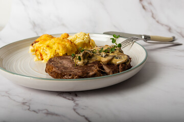 Eye fillet served with cauliflower gratin and mushroom sauce 