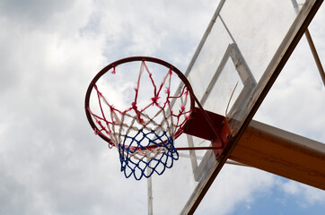 Basketball hoop on a backboard against cloudy sky