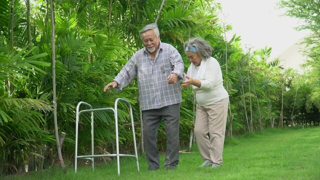 asian old couple walk with walker at  home. senior man using a walker  working with elder woman in the park . mature husband and wife Support together in garden