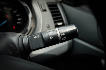 Switch off lights in a car. close-up Car integrated turning indicator with headlight switch toggle.