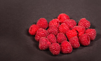 Fresh, ripe raspberries on a black background close up