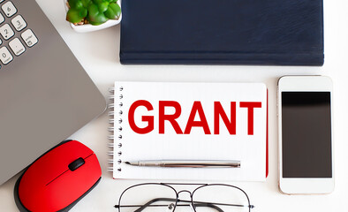 GRANT text on notepad,pen, office tools on the white background. Business concept