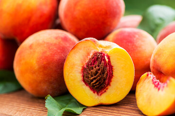 Fresh peaches on wooden table. Ripe peaches with leaves on a wooden board