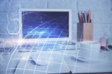 Double exposure of desktop with computer and world map hologram. International data network concept.