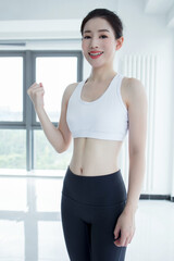 Fototapeta na wymiar Front view of sport woman in black exercise attire with sport bra and lycra pants with hands on hip.
