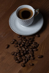 A cup of boiled coffee, coffee beans are next to it.