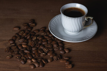 A cup of boiled coffee, coffee beans are next to it.