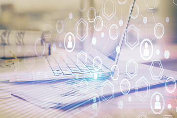 Computer on desktop with social network hologram. Multi exposure. Concept of international people connections.