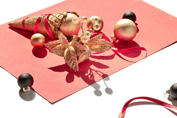 Golden waffle ice cream cone, Christmas gold and black balls and twig with berry on warn pink paper.