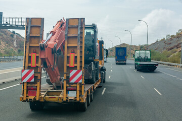 Truck with special semi-trailer to transport heavy construction machinery on the highway