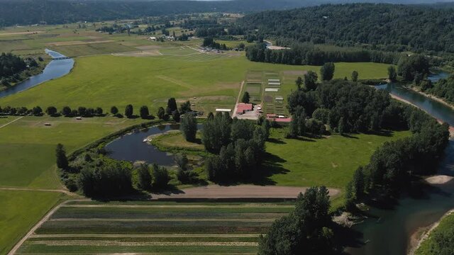 Rural American Farmland Aerial with Winding River and Vibrant Green Color Fields