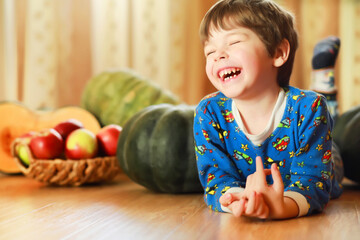 Little child choose a pumpkin at autumn. Child sitting on giant pumpkin. Pumpkin is traditional vegetable used on American holidays - Halloween and Thanksgiving Day.