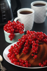 A cake with fresh red currant and tea