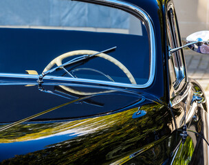 Retro car show. Black classic retro car. Vintage car fragment.