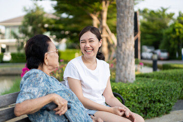Grandma sitting beside her granddaughter in a park.
