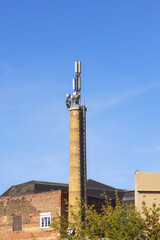 Old brick chimney with cell phone antennas.