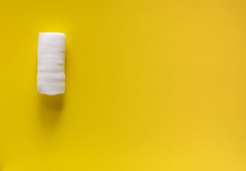 White medical bandage on yellow background close up