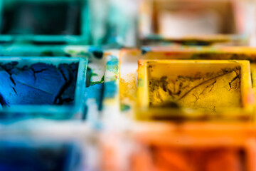 watercolor palette, yellow and blue.
close up of watercolor palette, with focus on yellow and blue.