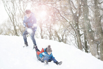 Children in the park in winter. Kids play with snow on the playground. They sculpt snowmen and slide down the hills.