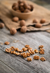 Fresh walnut kernels and whole walnuts in a bowl on rustic old wooden table. Healthy organic food, BIO viands, natural background. Copy space for your advertising text message