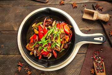 Roasted beef with vegetables in cast iron pan