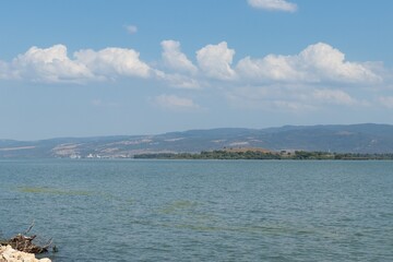Water landscape: view across the Danube to the Romanian coast. Wide river with a calm flow against the background of the sky and mountains