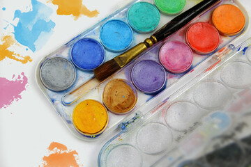 Watercolors and brushes on a white table