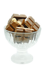 Pieces of chocolate in a glass vase isolated on white background. Different types of chocolate in vase.