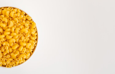 Raw dry uncooked Mini pipe rigate pasta spaghetti noodle on white bowl wooden background for basil tomato pesto sauce Homemade Italian food organic whole wheat vegan spaghetti for a healthy meal