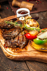 Grilled beef steaks with vegetables and sauce 