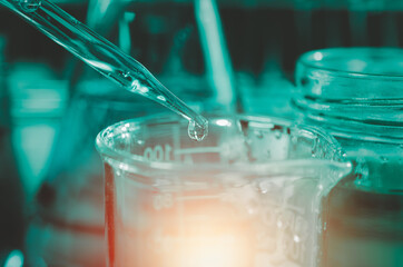 Scientist hand holding pipette dropping a sample into a test tube and science experiments ,Laboratory glassware containing chemical liquid,