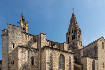 Fototapeta na wymiar Bell towers of the church of Saint Andéol against a backdrop of blue sky, France