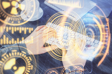 Technology theme hologram with man working on computer on background. High tech concept. Multi exposure.