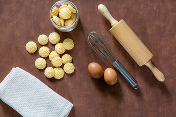The process of making homemade cookies on a dark brown wooden cooking table. Ingredients for baking biscuits