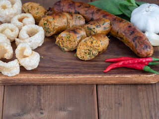 Grilled sausages and pork snack with herb on a wooden table