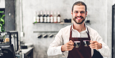 Portrait of  barista man small business owner holding cup of coffee in the cafe or coffee shop.Male barista standing at cafe