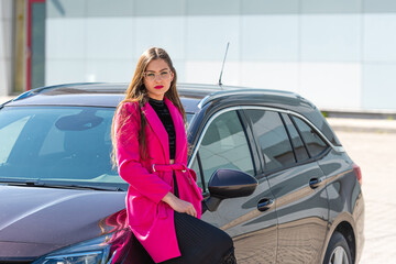 a young woman with glasses leaning against the car