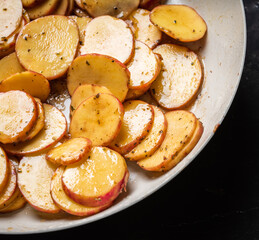 Roasted slices of young potatoes on the pan. Selective focus. Shallow depth of field.