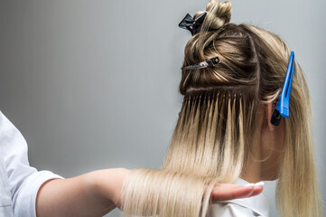 Hair extensions to a client close up in a beauty salon
