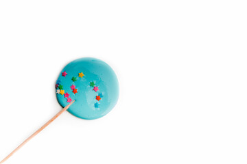 Hand made blue lollipop on wooden stick on white background. The concept of sweets for the holidays, birthday. Candy bar. Flat lay. Copy space for text.