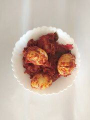closeup of a egg curry in a bowl isolated on white background