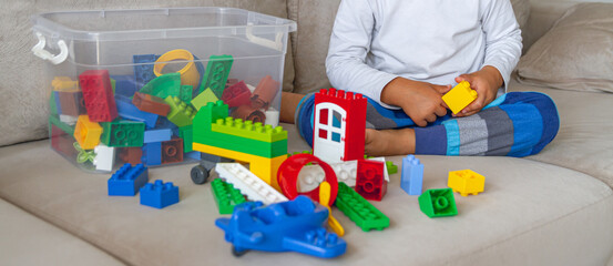 Child playing with toy blocks sitting on sofa