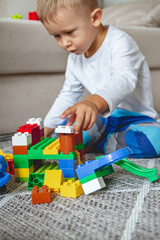 Child playing with toy blocks sitting on floor