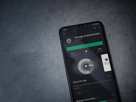 Lod, Israel - July 8, 2020: Google Authenticator app play store page on the display of a black mobile smartphone on dark marble stone background. Top view flat lay with copy space.