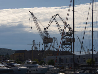 Fototapeta premium Port cranes for unloading and loading ship transport, Croatia port in the city of Trogir