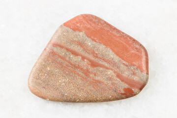 closeup of sample of natural mineral from geological collection - polished Siltstone (Aleurite) rock on white marble background from Palaselga, Karelia