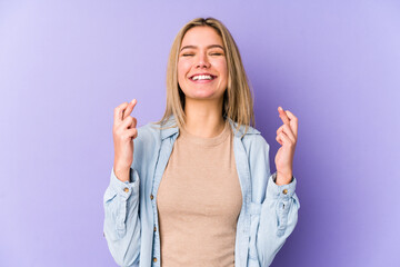 Young blonde caucasian woman isolated crossing fingers for having luck