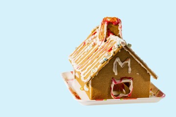 Close up view of gingerbread house on blue background. Holidays and traditions concept.