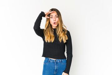 Young caucasian woman isolated on white background shouts loud, keeps eyes opened and hands tense.